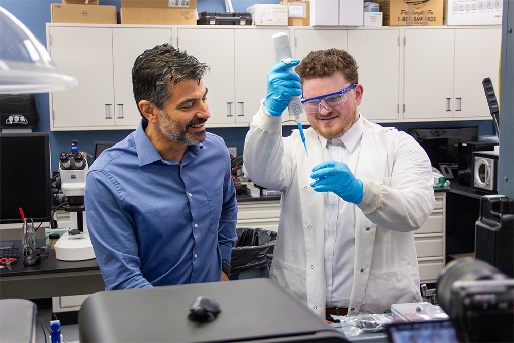 Ph.D. student works with faculty member in lab